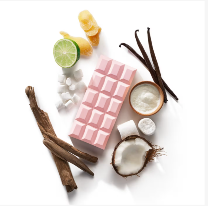 Pink chocolate bar with vanilla beans, lime, coconut, and cinnamon on a white background